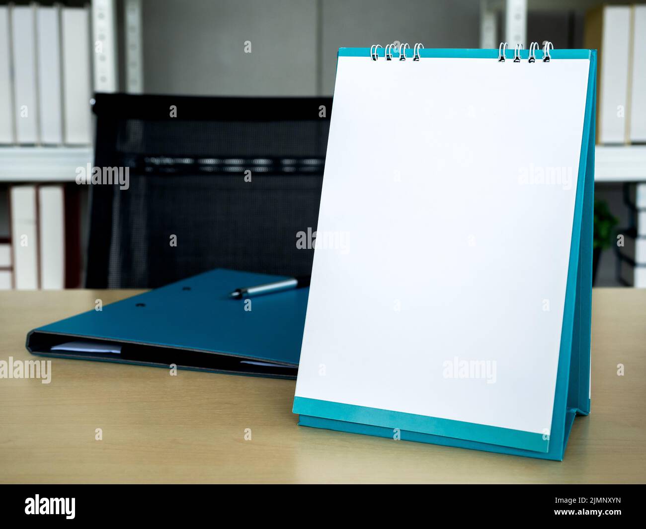 White blank desktop fliptop calendar template vertical style near the document folder on wood