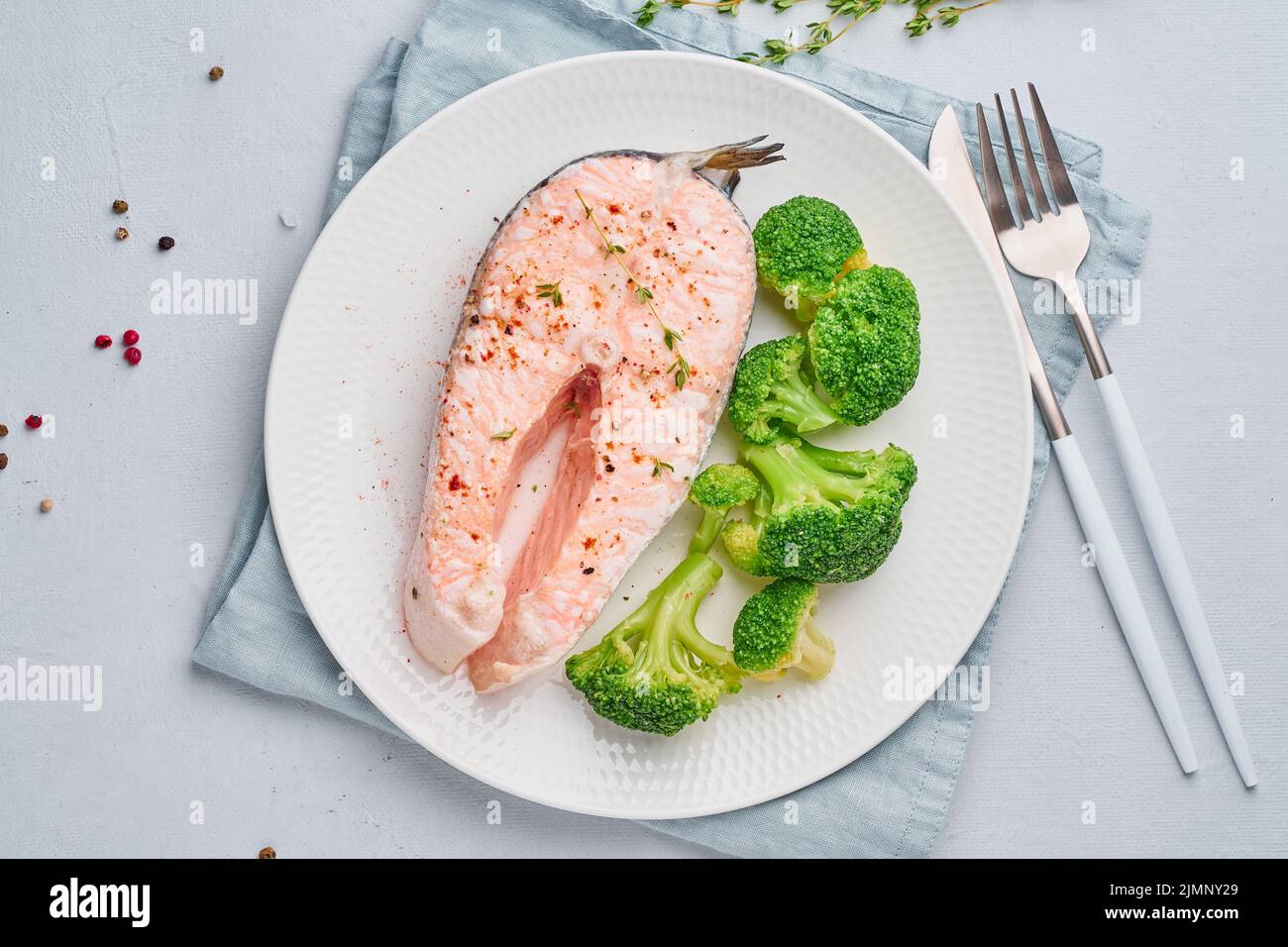 Steam salmon, broccoli, paleo, keto or fodmap diet. White plate on blue table, top view Stock Photo