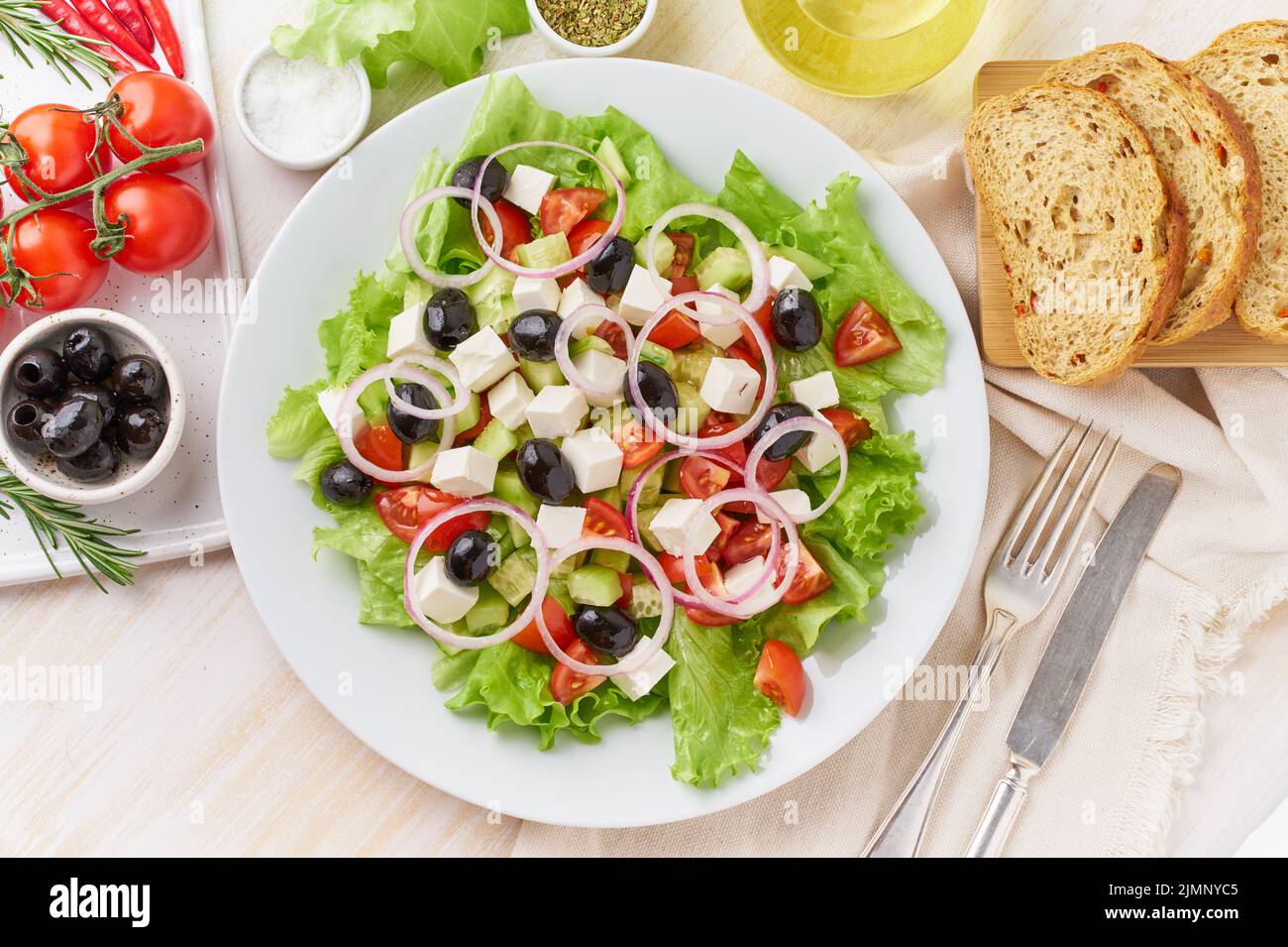 Greek salad on white plate on old rustic white wooden table, fresh salad Stock Photo