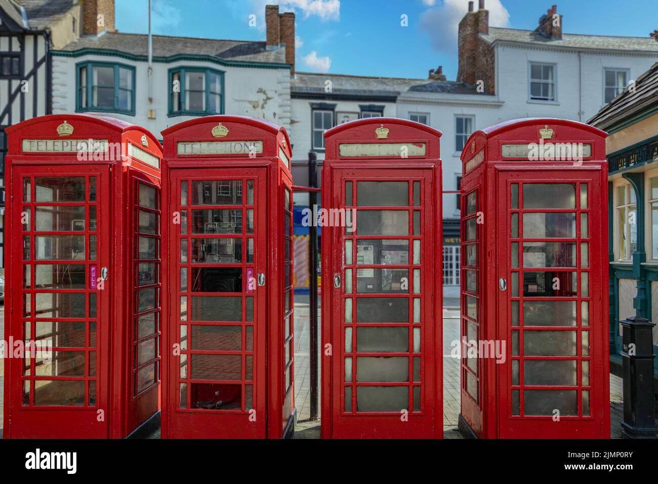In Ripon Market Square, UK, you'll find four iconic British telephone boxes, which are usually found in rural areas due to bad mobile reception. Stock Photo