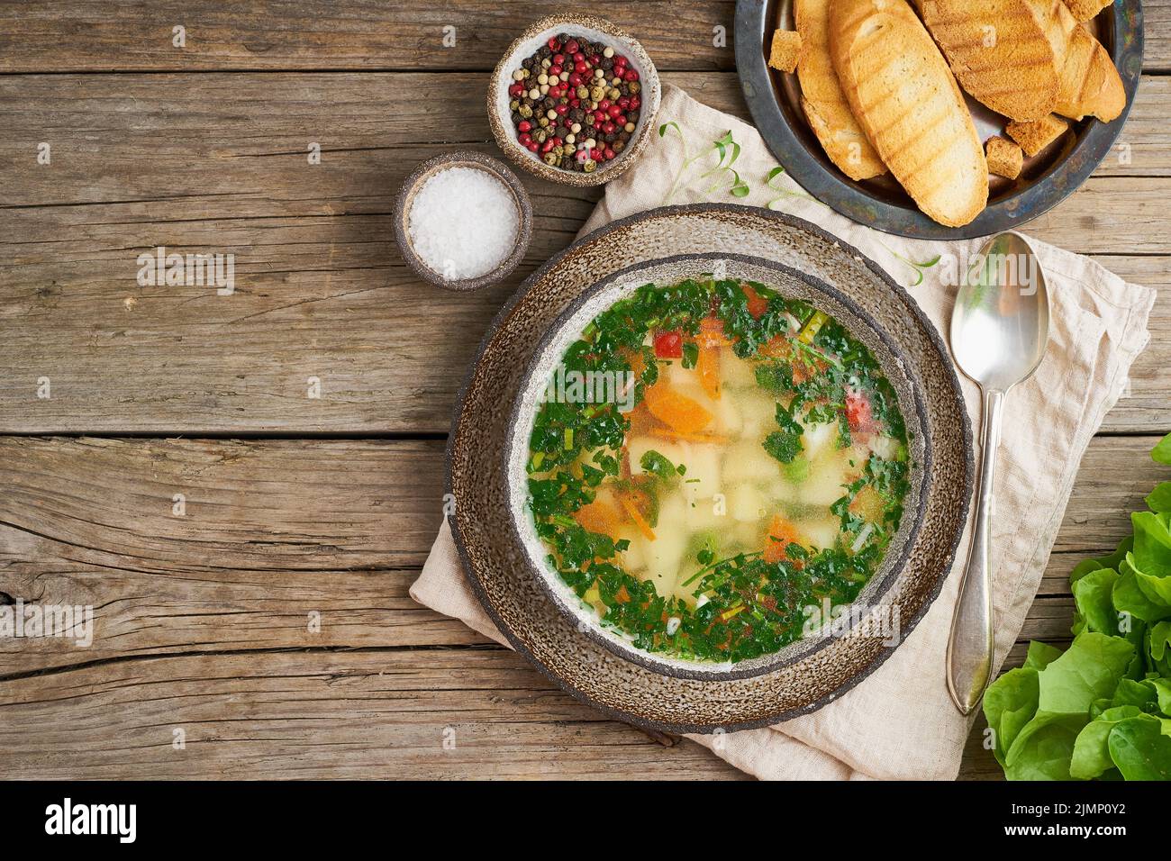Rustic chicken soup with garnish, parsley, vegetables, homemade dish on