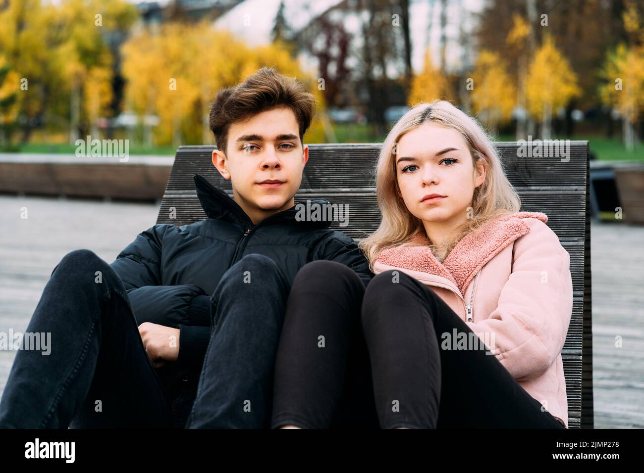 Teenage love concept. Cute brunette guy ??? young blonde girl Stock Photo