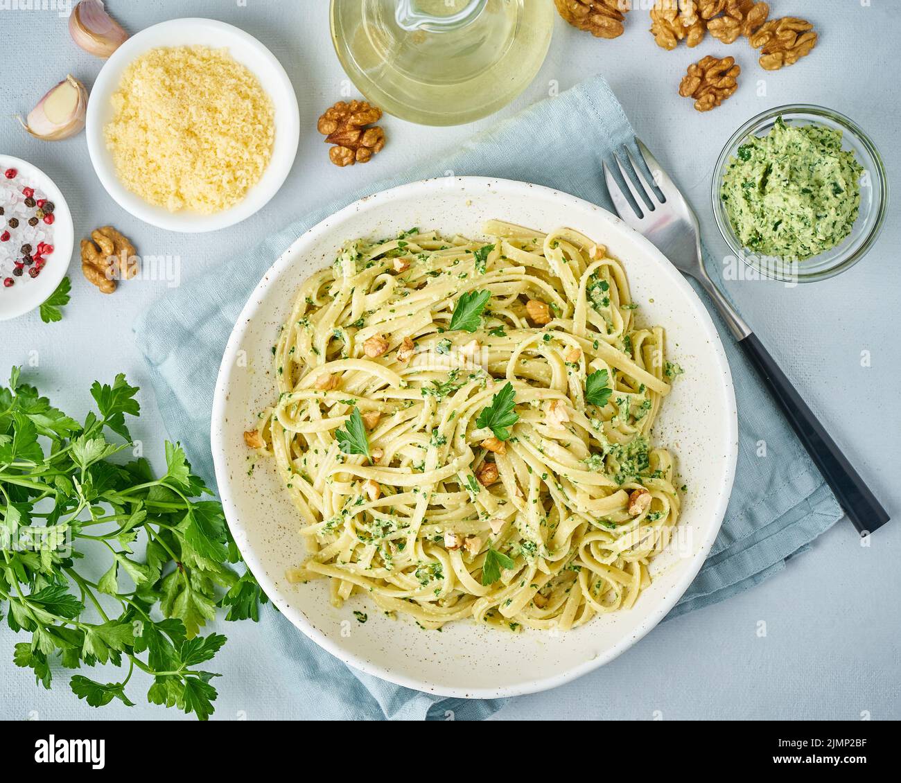 Pesto pasta, bavette with walnuts, parsley, garlic, nuts, olive oil. Top view, close-up Stock Photo