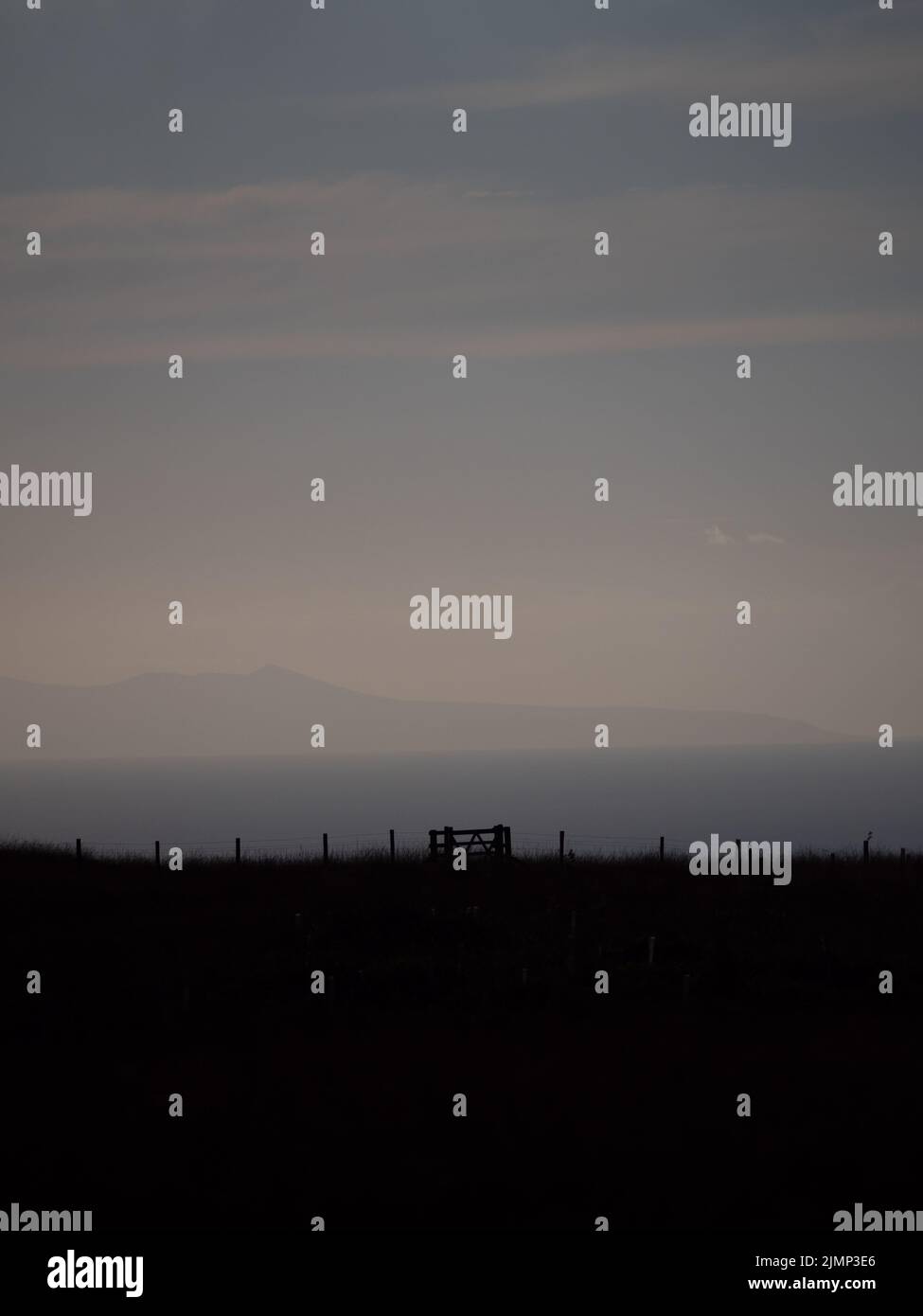 Lake District view, silhouette of a farm gate at pink sunset Stock Photo