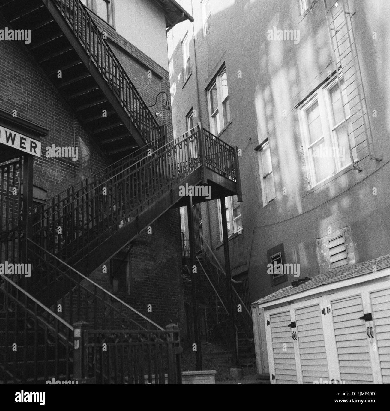 Lonely Urban Scene With Shadows On Buildings And Fire Escape Stock Photo