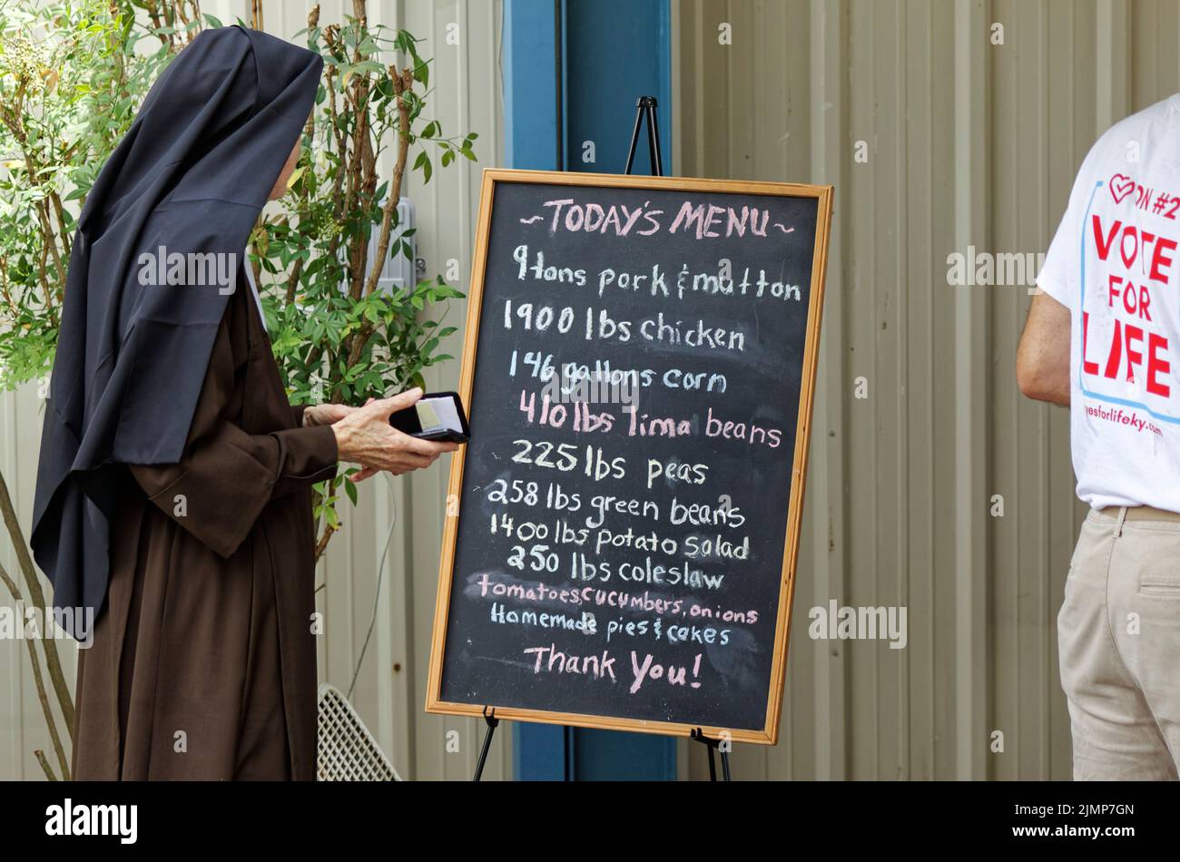 Fancy Farm, KY, USA. 06th Aug, 2022. A nun reviews the menu while waiting in line to eat at the 142nd St. Jerome Fancy Farm Picnic. A fundraiser for St. Jerome Catholic Church, the picnic is known for serving tons of barbecued meats and inviting political speakers to poke fun at one another in front of a crowd that's both permitted and encouraged to heckle. (Credit: Billy Suratt/Apex MediaWire via Alamy Live News) Credit: Apex MediaWire/Alamy Live News Stock Photo