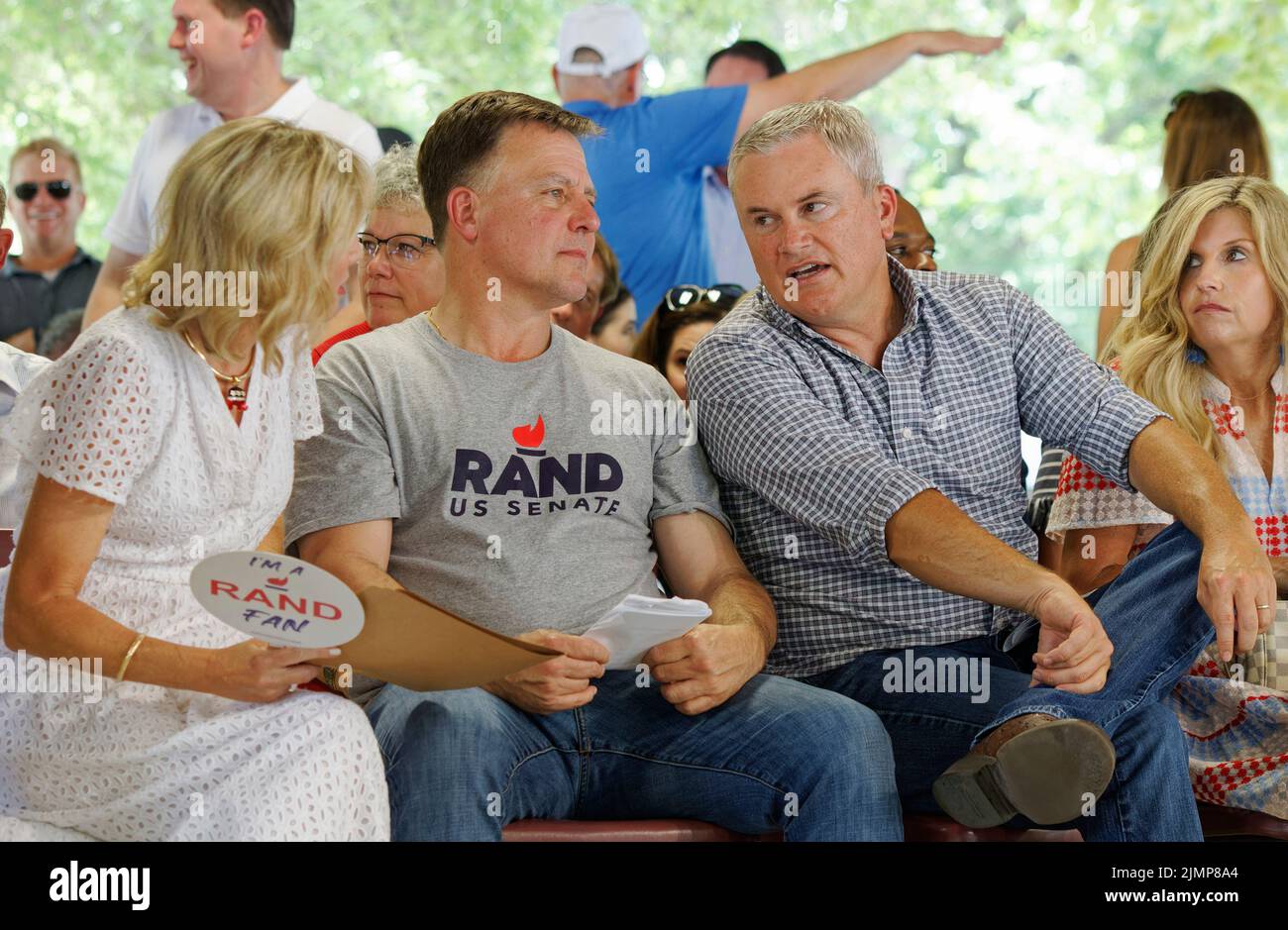 Fancy Farm, KY, USA. 06 Aug 2022. Republican Congressman James Comer (second from right) talks with Kelley Paul (left) and Rob Givens, state director for Sen. Rand Paul, as his wife, Tamara Comer (right), looks on during the 142nd St. Jerome Fancy Farm Picnic. A fundraiser for St. Jerome Catholic Church, the picnic is known for serving tons of barbecued meats and inviting political speakers to poke fun at one another in front of a crowd that's both permitted and encouraged to heckle. (Credit: Billy Suratt/Apex MediaWire via Alamy Live News) Stock Photo