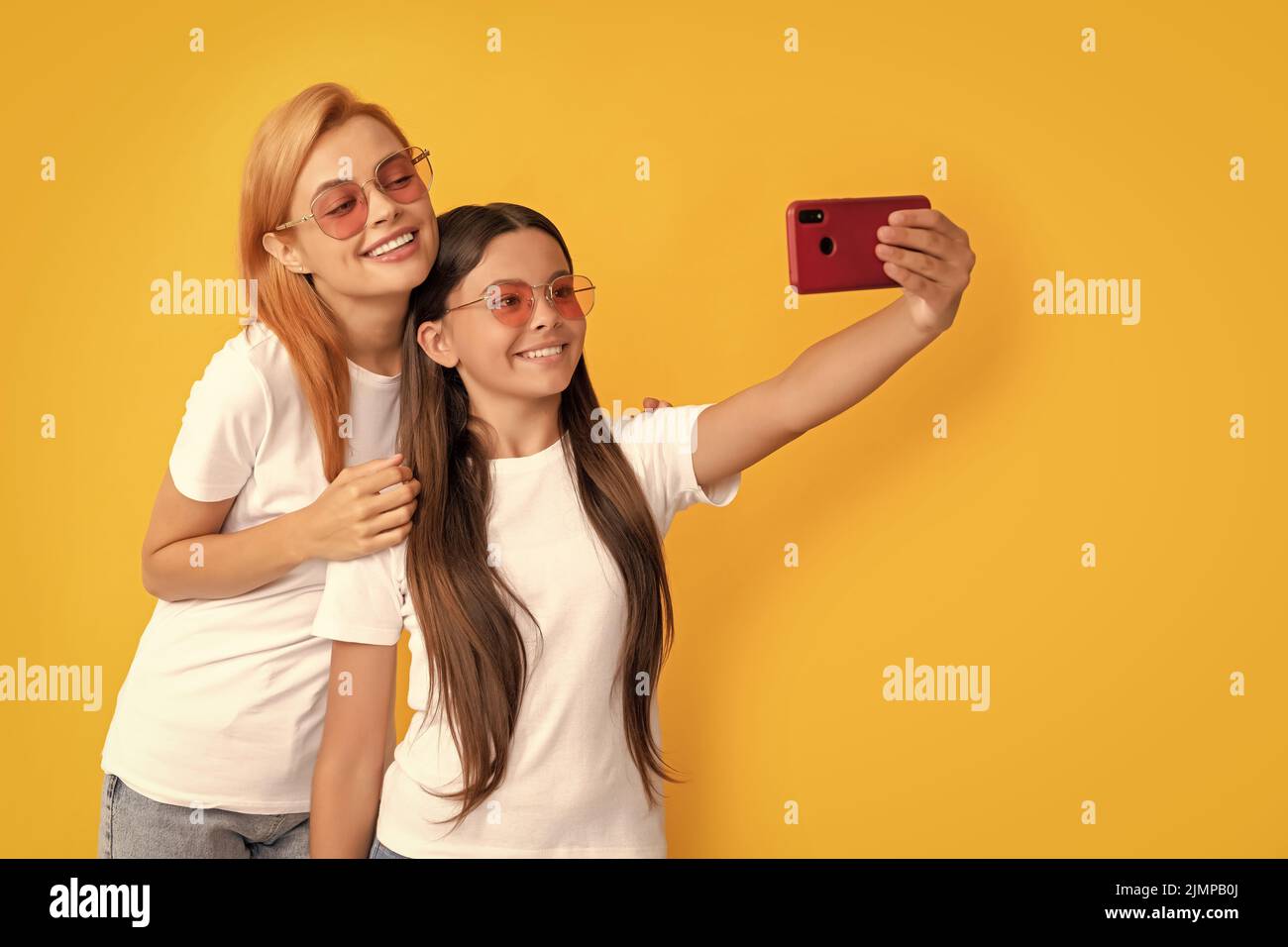 mom and kid bloggers. lovely woman and girl take selfie with smartphone. selfie family. Stock Photo