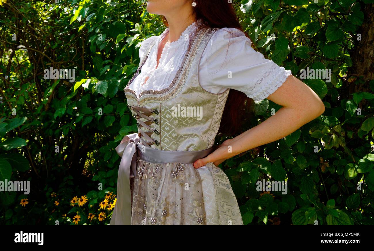 a woman in a beautiful luxurious traditional Bavarian or Austrian dirndl dress (or Tracht) (Munich, Bavaria, Germany) Stock Photo