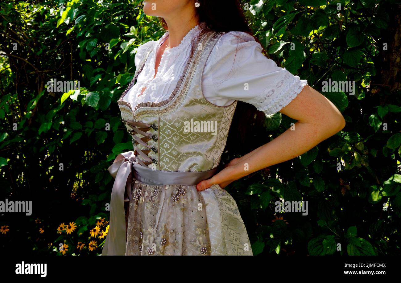 a woman in a beautiful luxurious traditional Bavarian or Austrian dirndl dress (or Tracht) (Munich, Bavaria, Germany) Stock Photo