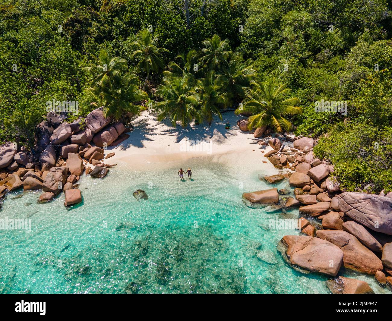 Praslin Seychelles tropical island with withe beaches and palm trees, couple men and women mid age on vacation at the Seychelles Stock Photo