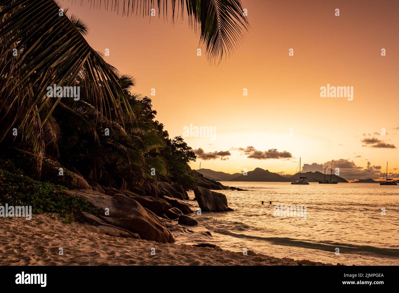 Anse Patates beach, La Digue Island, Seyshelles, white beach with blue ocean and palm trees, sunset on the beach Stock Photo