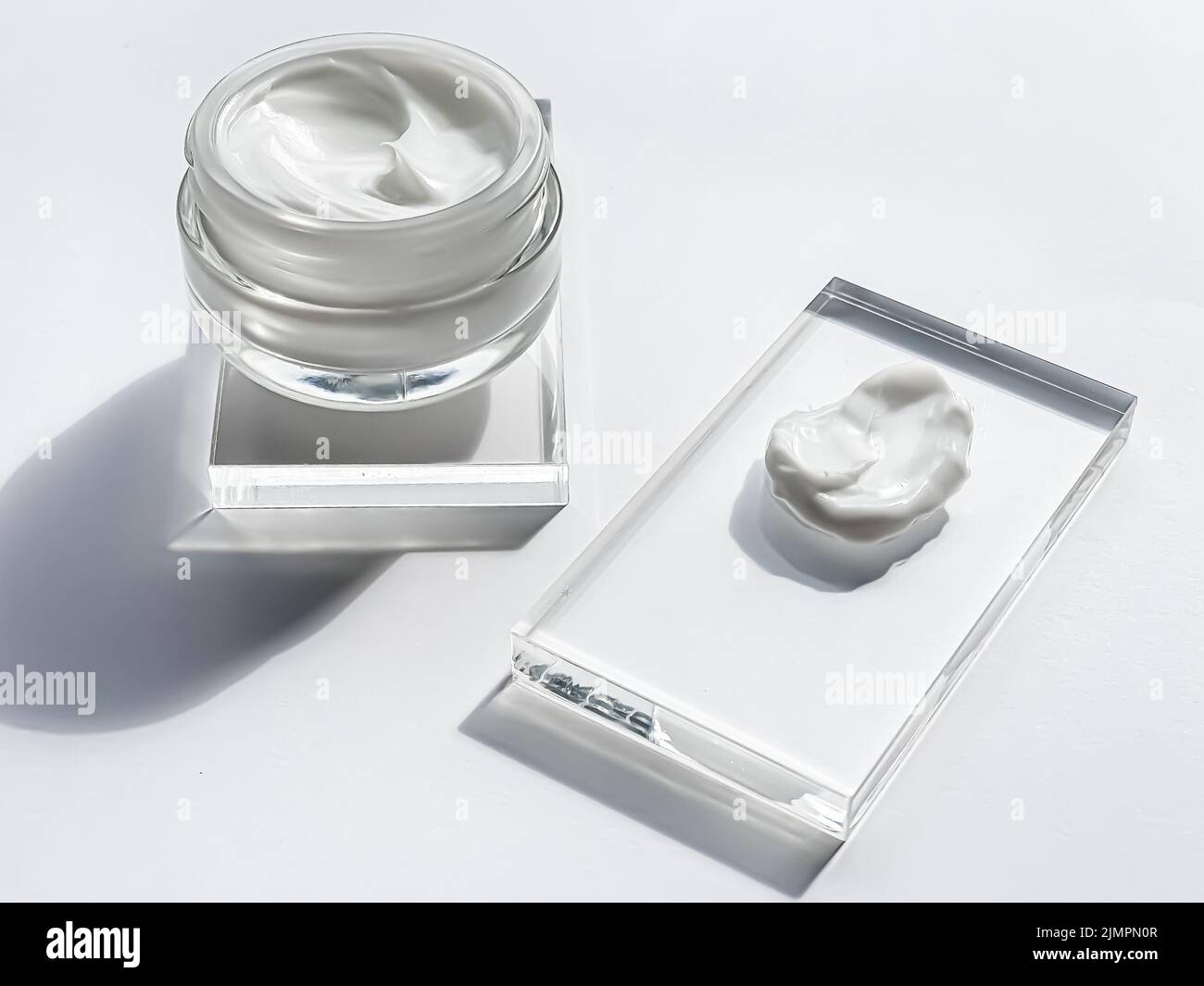 Face cream moisturiser jar and product sample on glass, beauty and