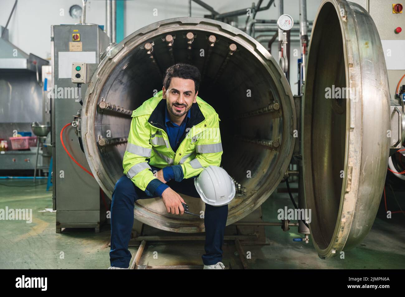 Happy caucasian engineer man in safety uniform sitting and reporting on