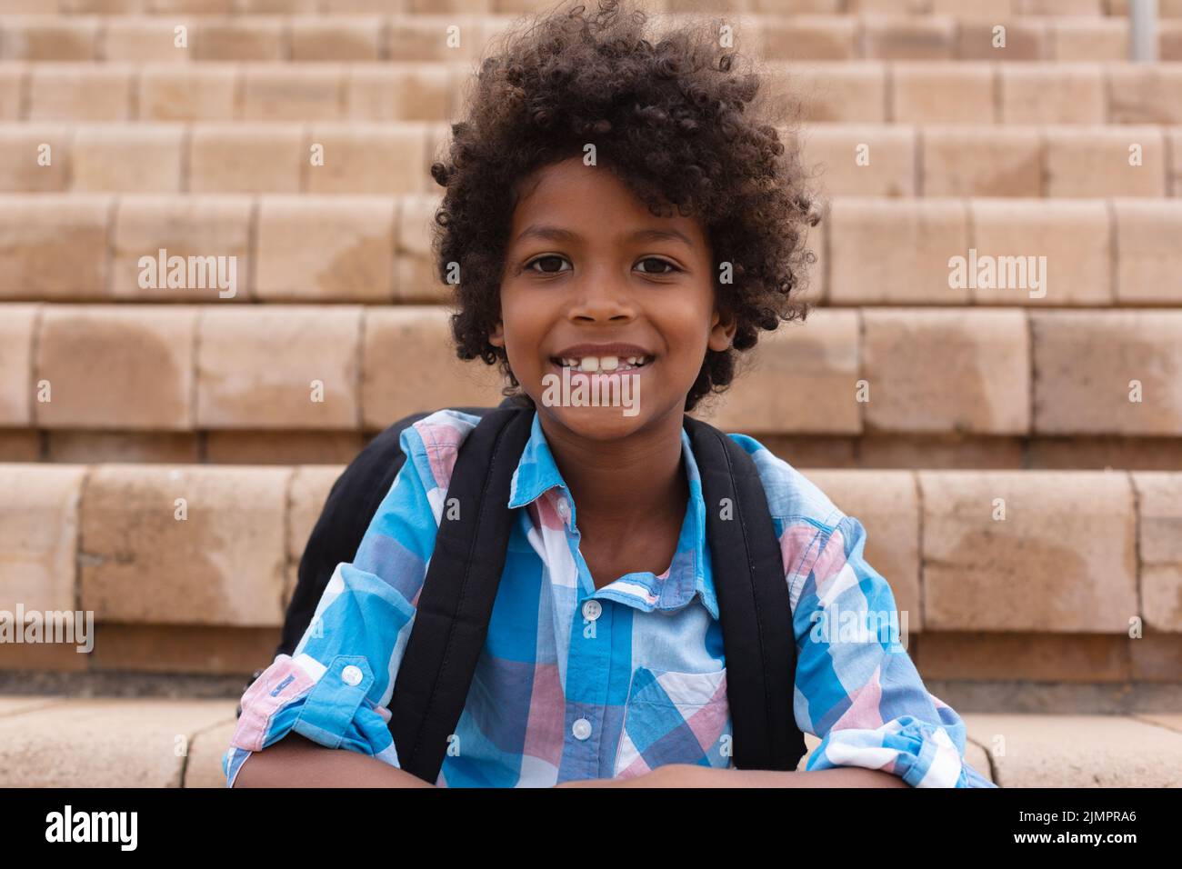 Portrait of smiling african american elementary boy with backpack ...