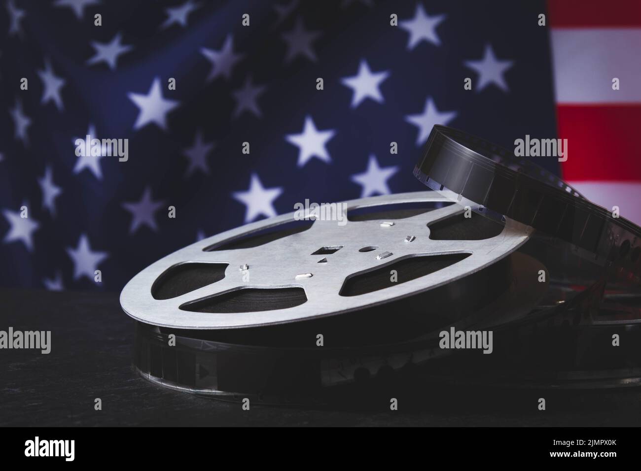 American cinema. Cinematography in the USA. Old film reel on the background of the flag of America. Stock Photo