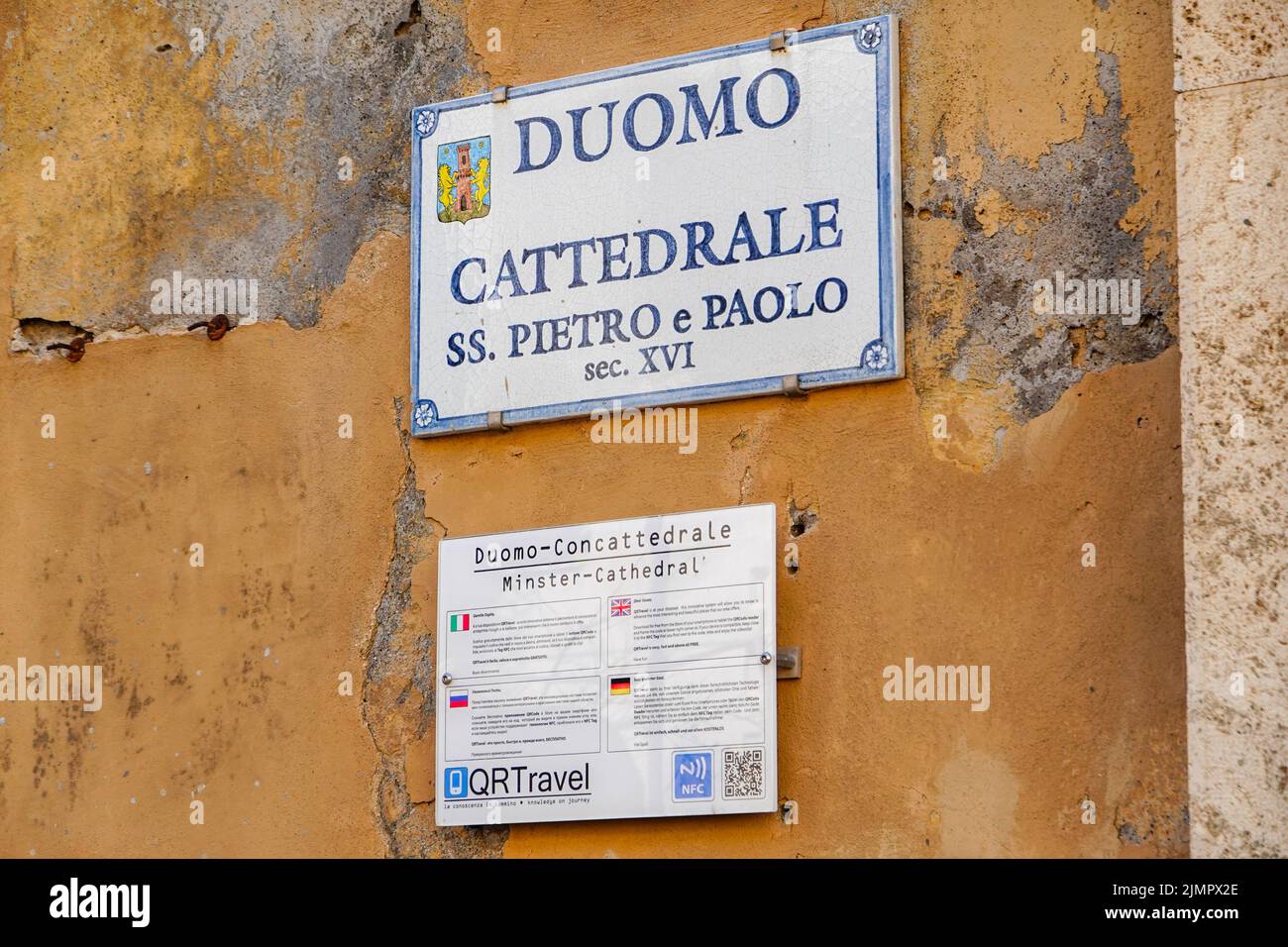 Sign, plaque, on the side of the Pitigliano Duomo, the hill town located in the Province of Grosetto, Italy. Stock Photo