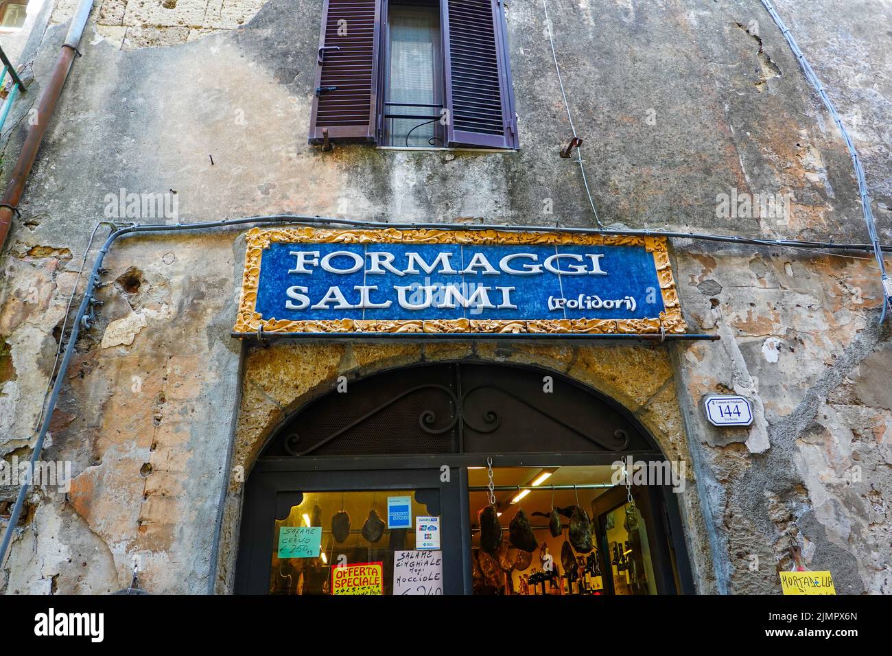 Entrance to a cheese and cured meats shop located in the Tuscan hill town of Pitigliano in the Province of Grosetto, Italy. Stock Photo
