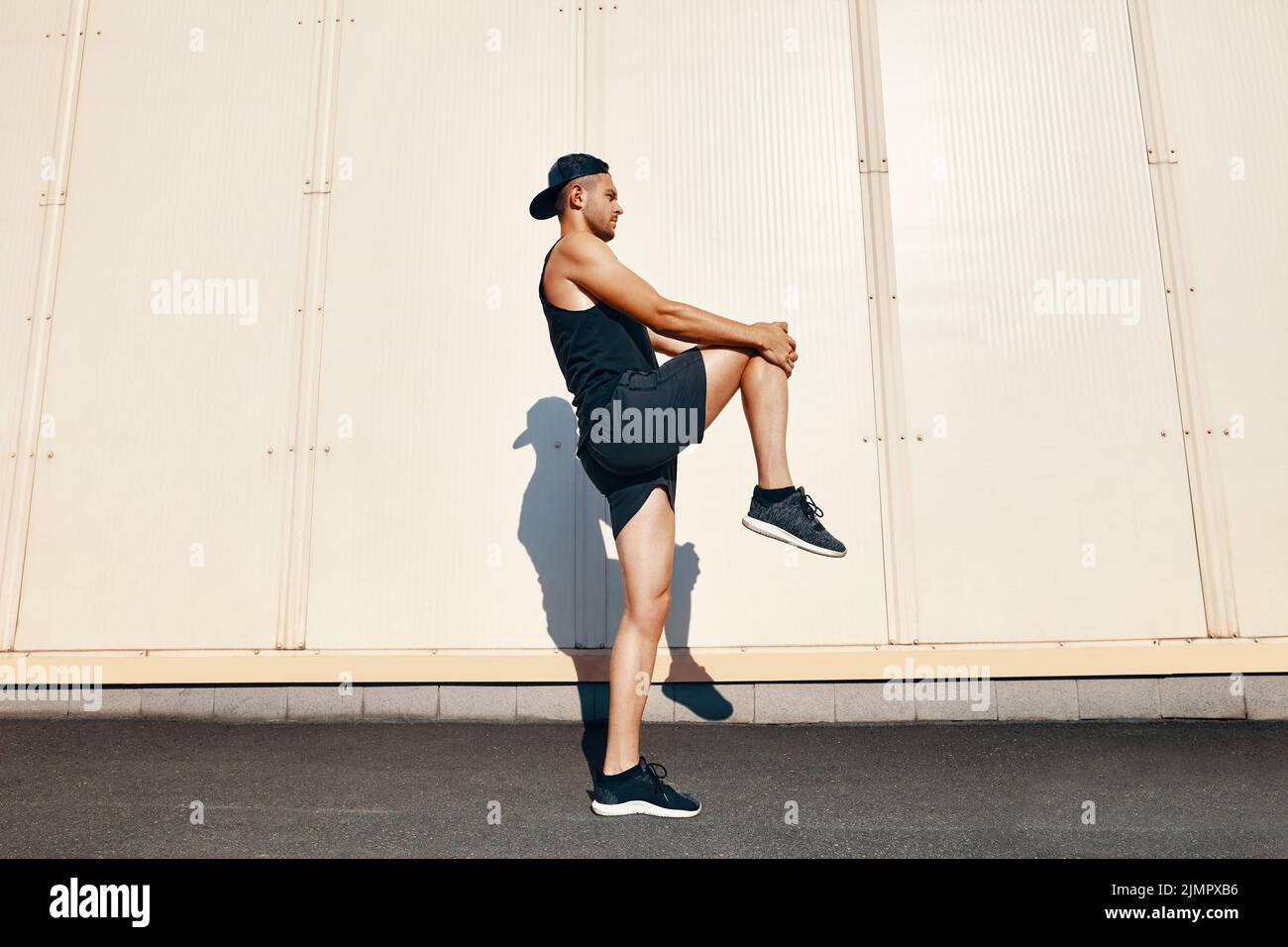 Sporty athlete man doing warm up and stretch legs Stock Photo