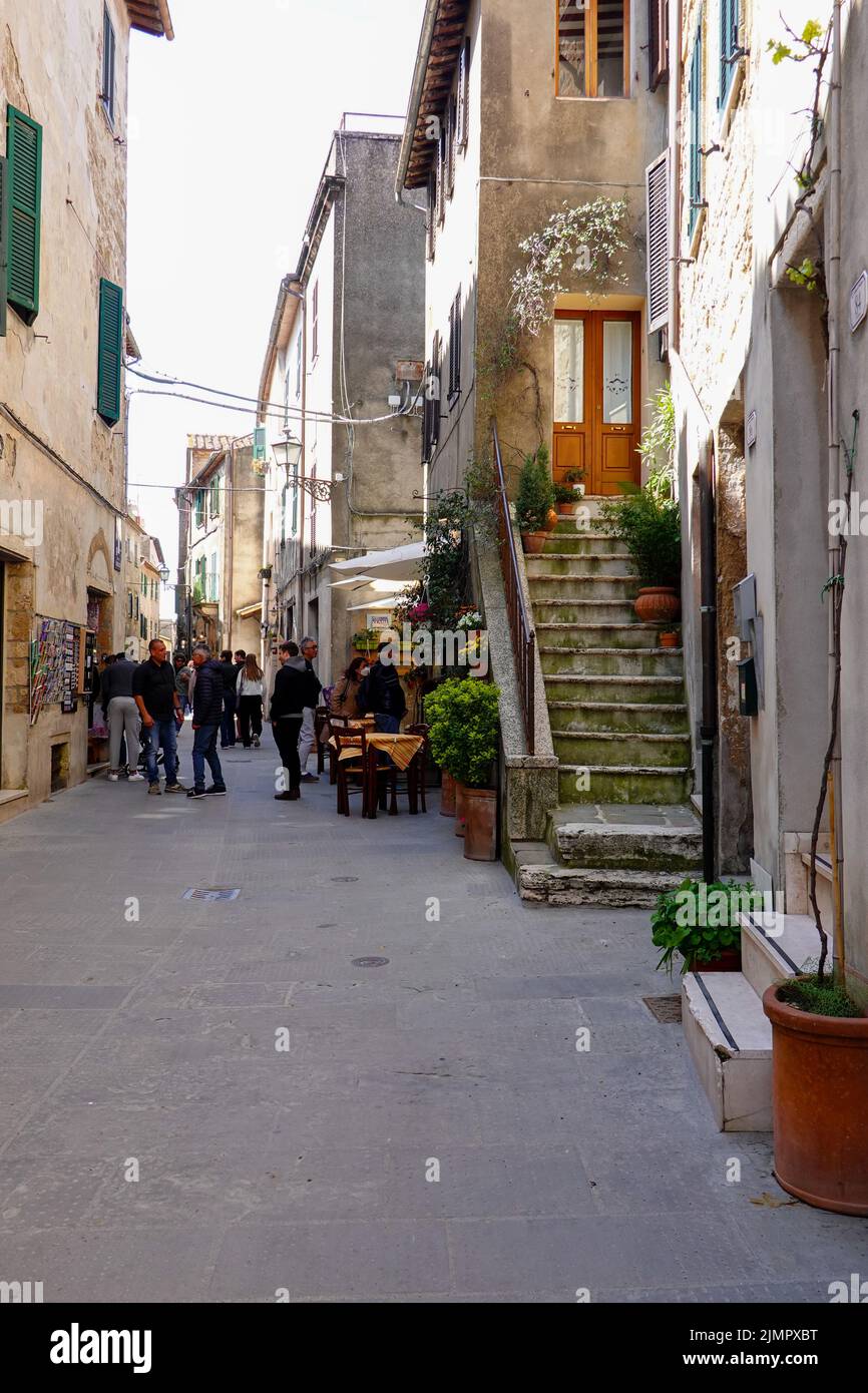 People on a narrow Pitigliano street in the Province of Grosetto, Italy. Stock Photo