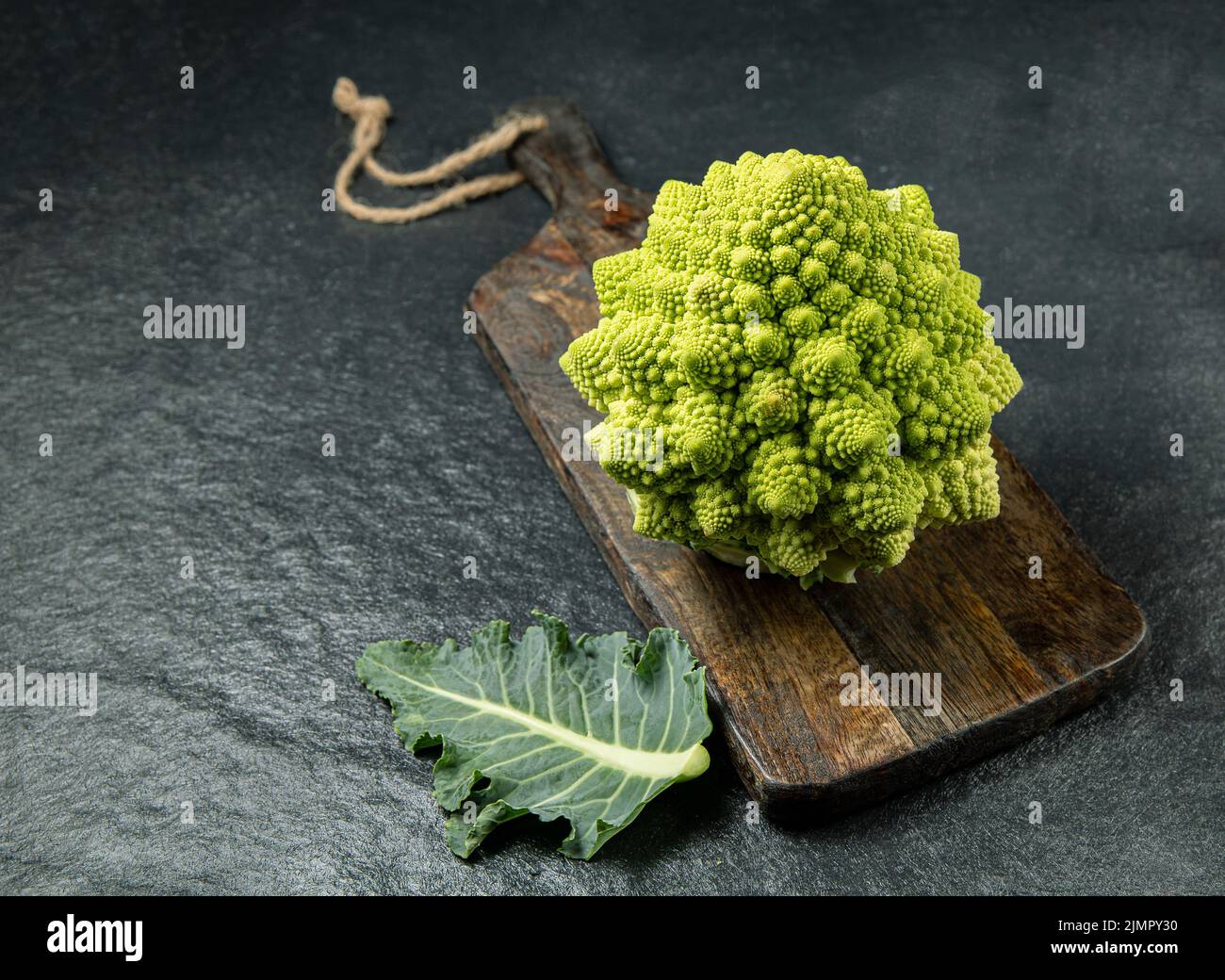Romanesco broccoli head on a dark stone surface, cabbage, close up, fibonacci sequence, for those who love mathematics Stock Photo