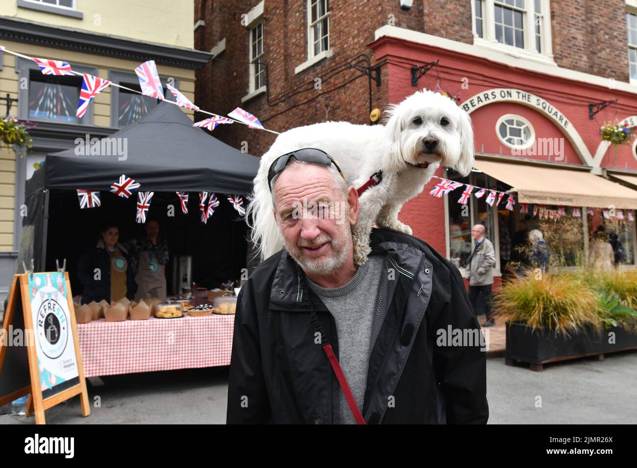 Man walking with his pet dog on his shoulders in Britain 2022 Stock Photo
