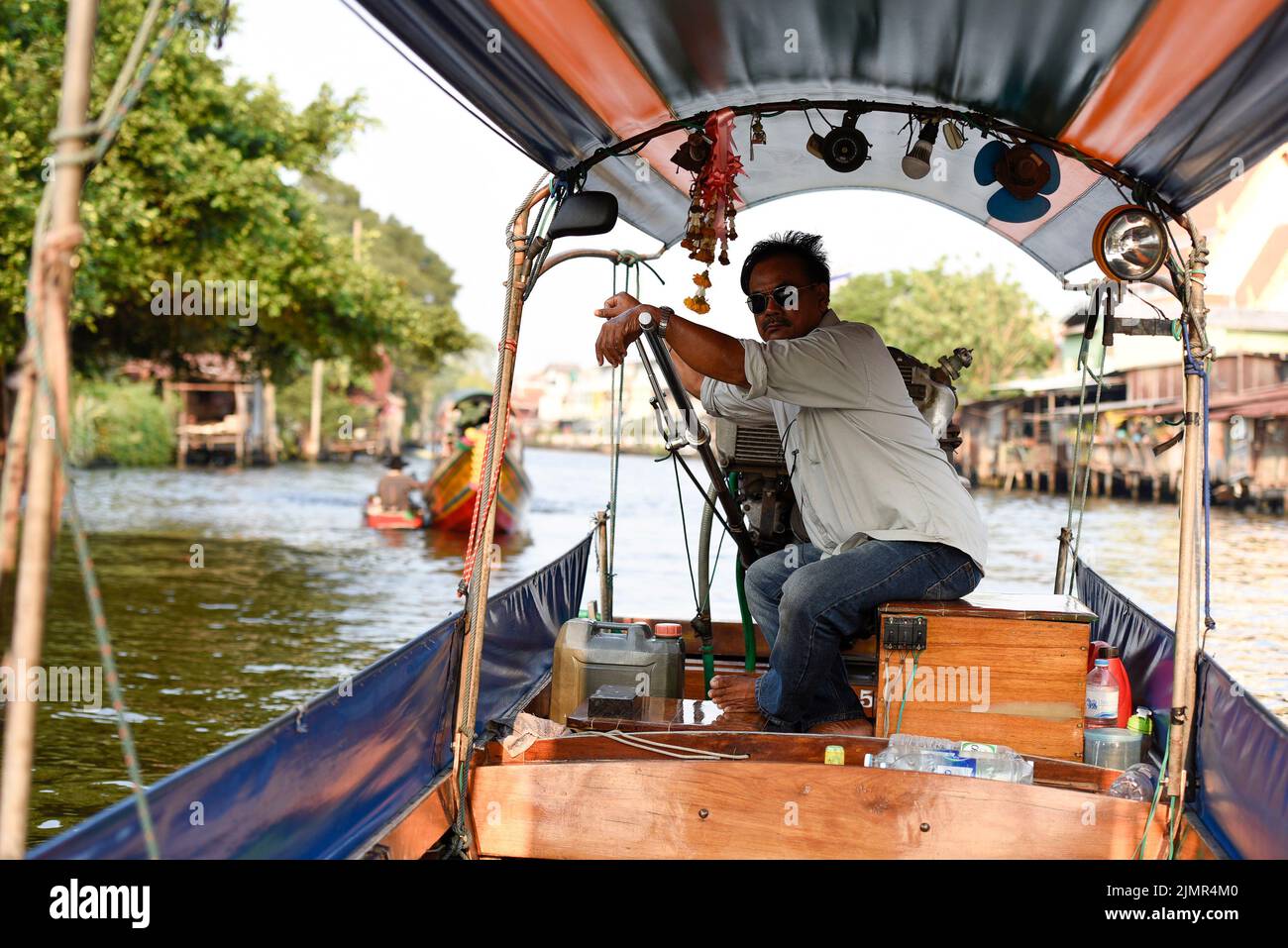 Chao Phraya River Canal Cruise boat and captain. Traditional canal tour boats. Stock Photo