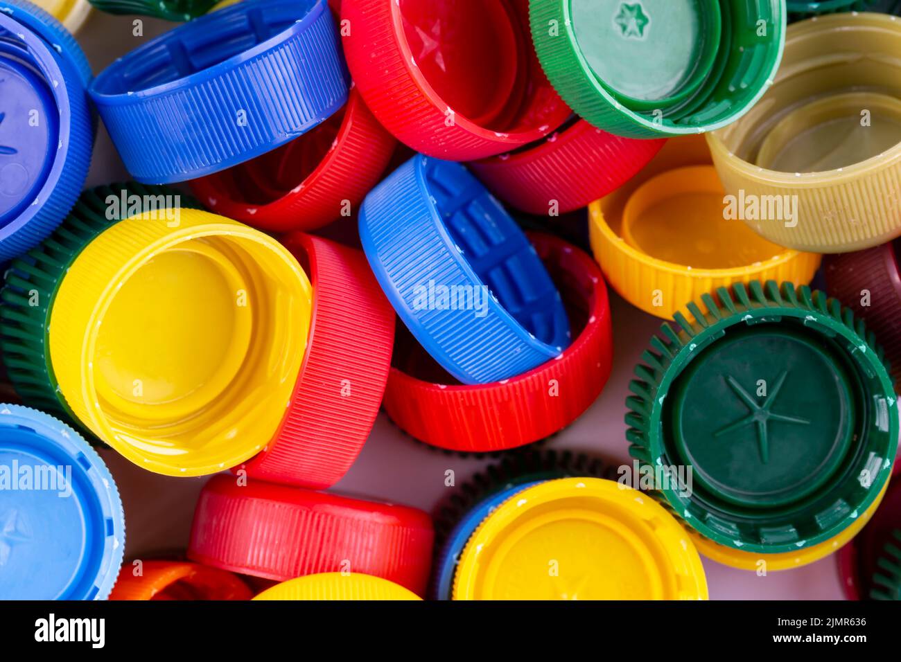 Plastic bottle caps background. Cap material is recyclable. Recycling collection and processing