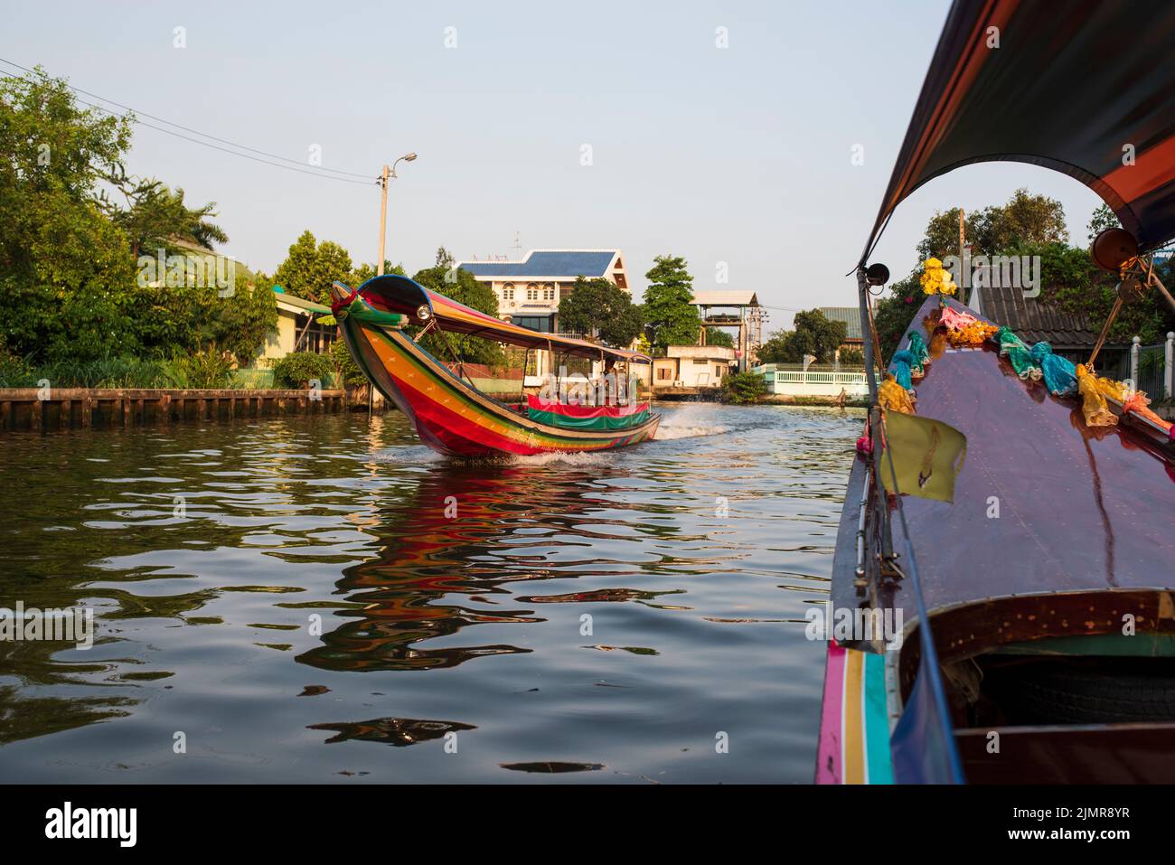 Chao Phraya River Canal Cruise boats and tourists. Traditional canal houses and life. Stock Photo