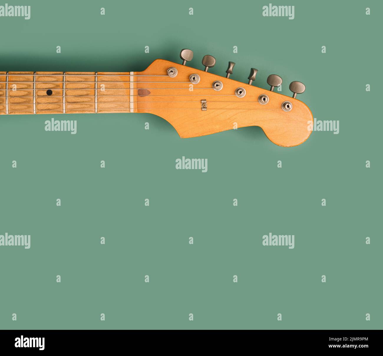 Electric guitar headstock on a pastel green background. Rock 'n' roll