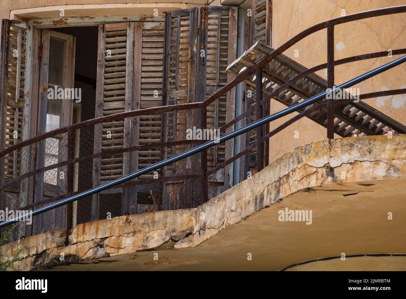 Broken woodne window and balcony of an abandoned house in the Ghost Resort City of Varosha Famagusta, Cyprus Stock Photo