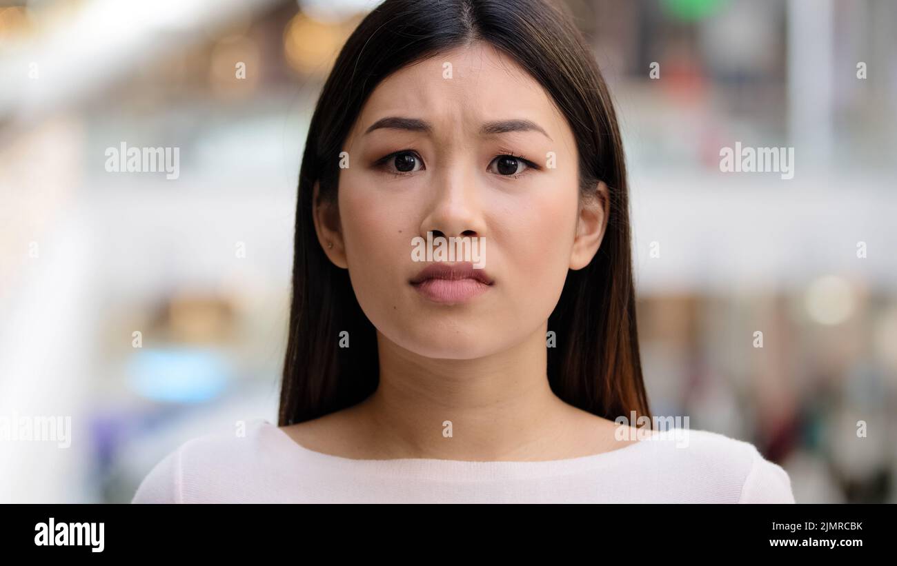 Close up female emotional face asiang girl shocked stressful woman model frightened lady scared horror disgust shock afraid unpleasant bad news Stock Photo