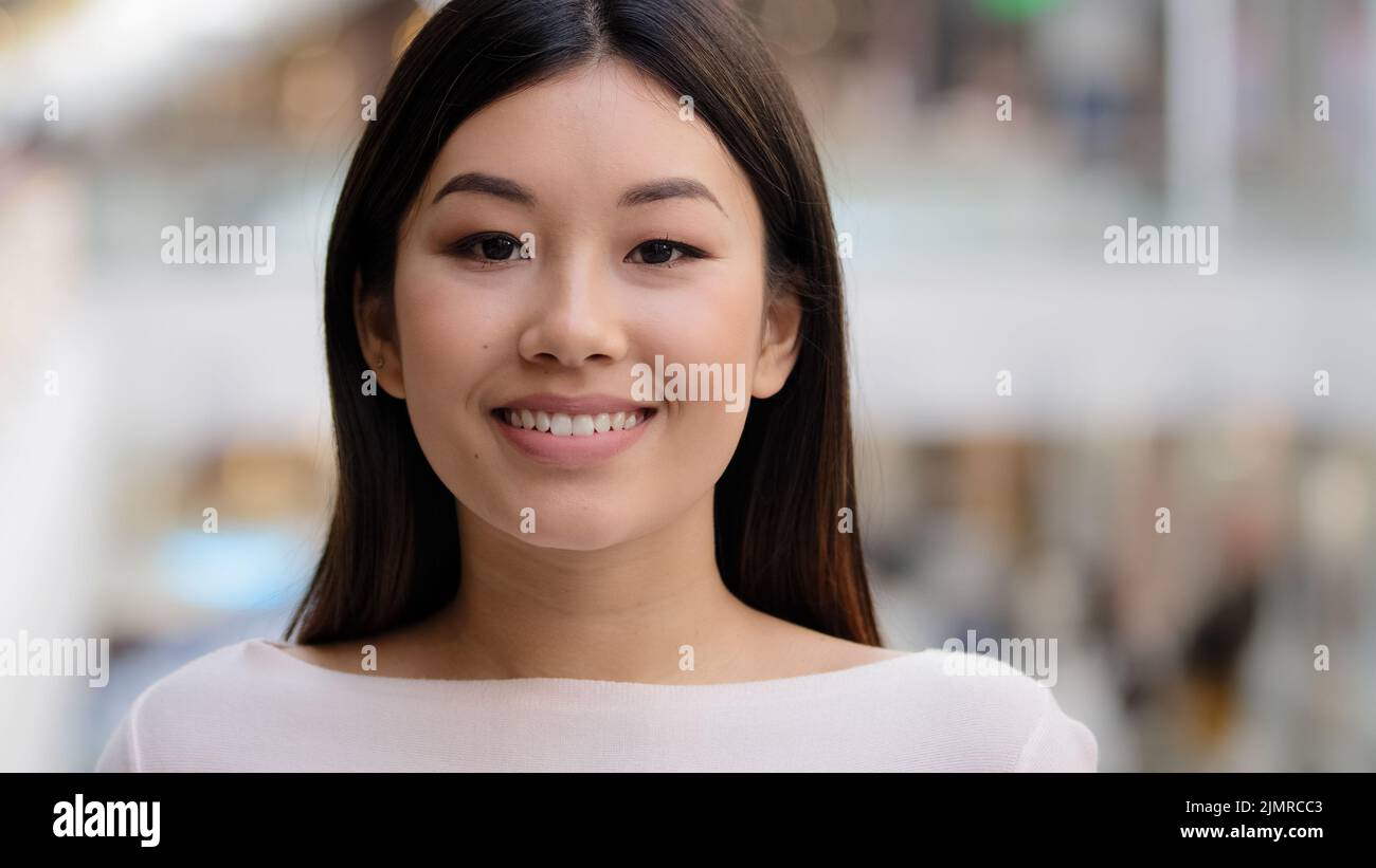 Asian headshot happy optimistic millennial girl 20s brunette woman with natural make-up businesswoman wife girlfriend teacher worker turns head Stock Photo