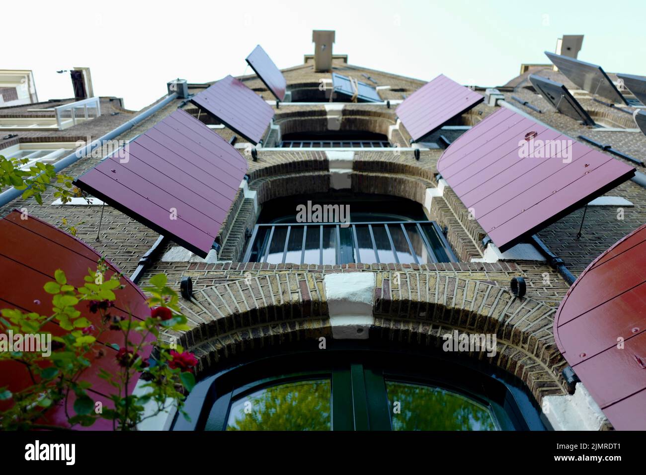 Merchant house with red open window shutters in Amsterdam Stock Photo