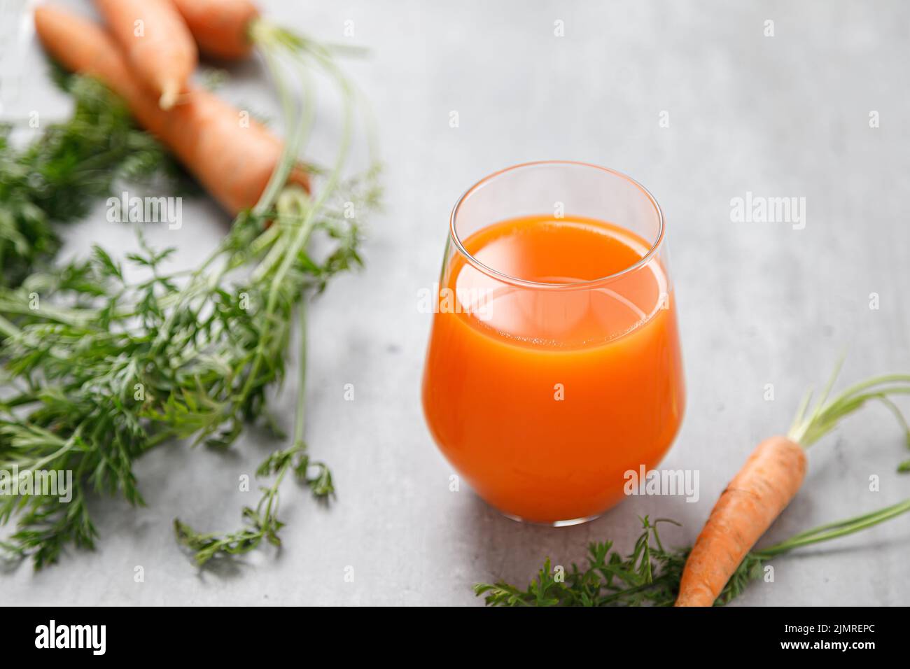 Carrot juice in a glass and fresh carrots with leaves Stock Photo Alamy