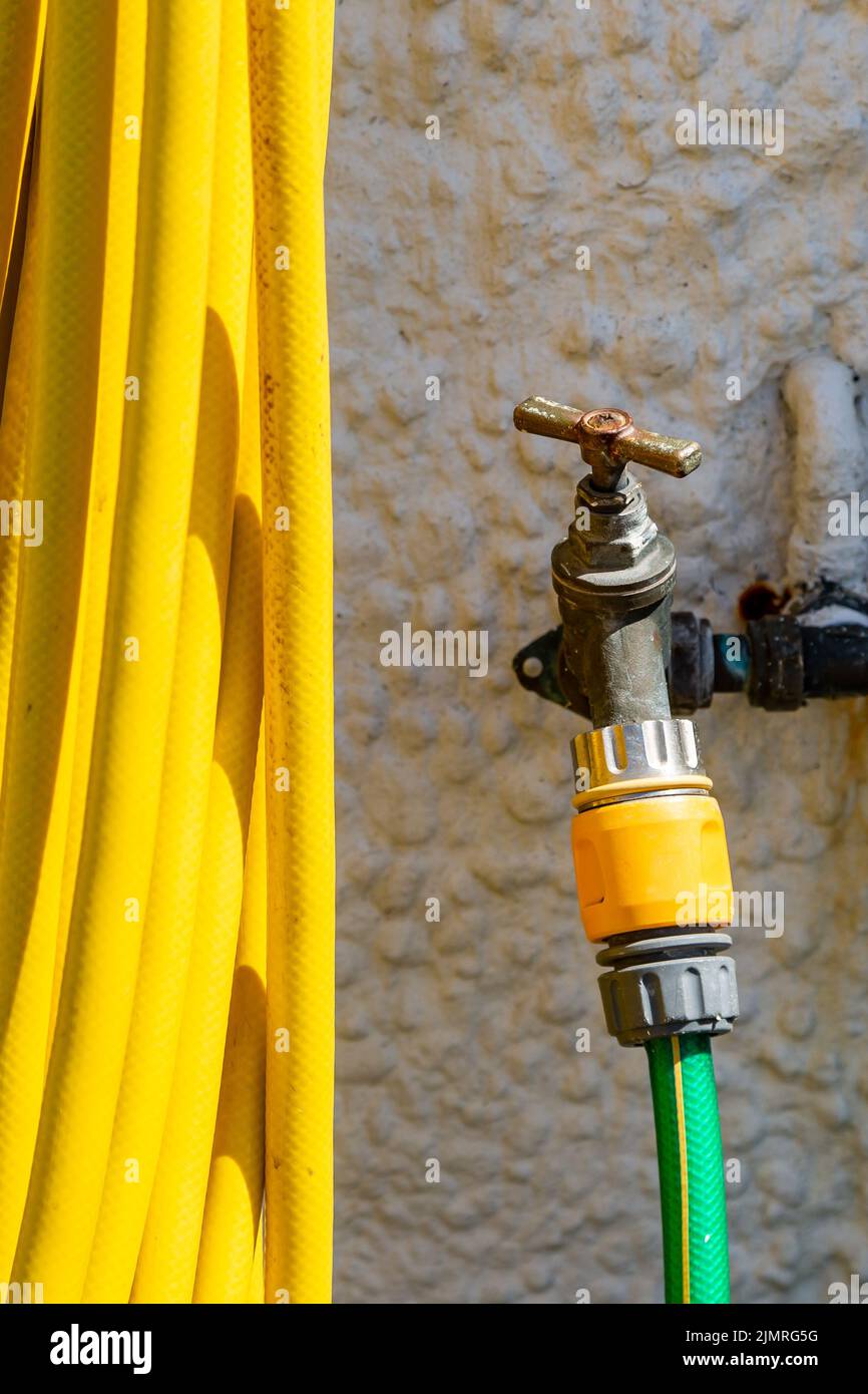 A hosepipe attached to an outside tap Stock Photo Alamy