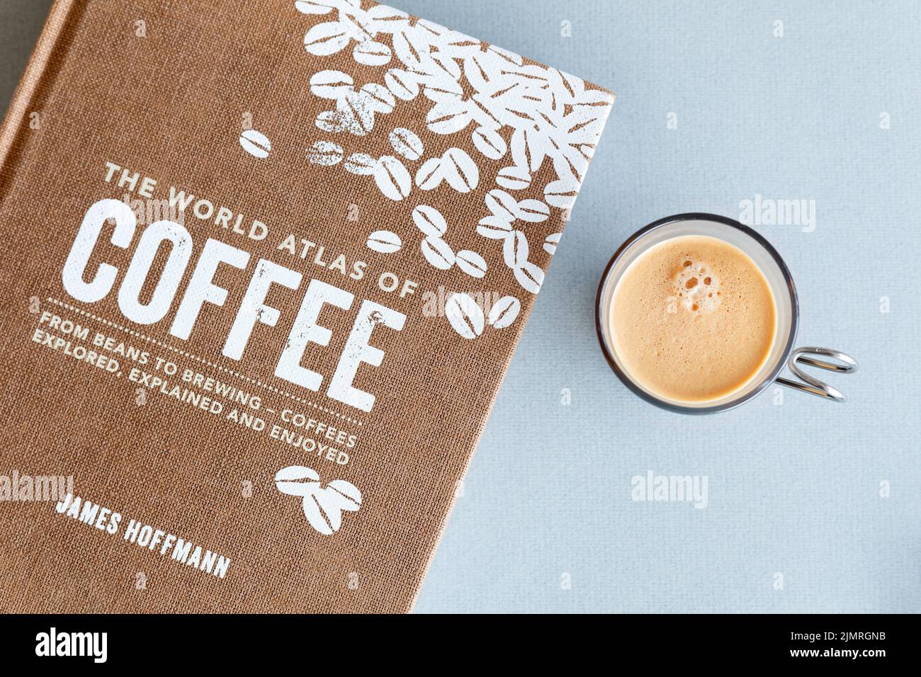 A book dedicated to coffee and coffee making called The World Atlas of Coffee written by James Hoffmann. An espresso coffee sits beside the book Stock Photo