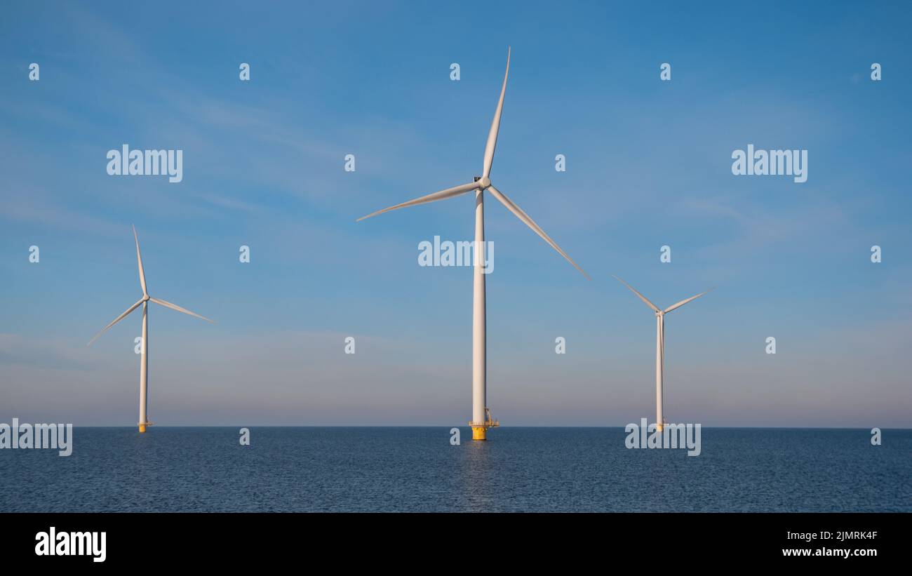 Huge windmill turbines, Offshore Windmill farm in the ocean Westermeerwind park , windmills isolated at sea on a beautiful brigh Stock Photo