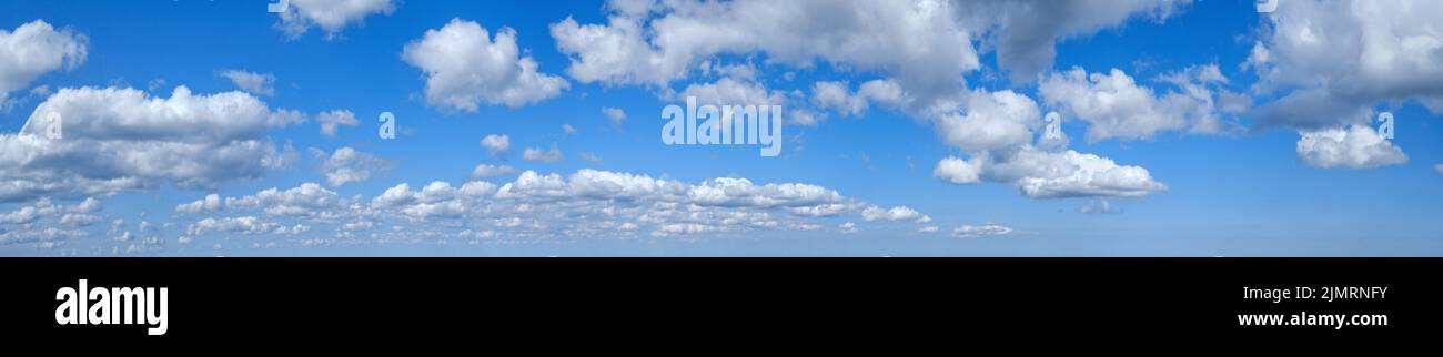Blue sky with clouds in sunshine (wide natural cloudscape background panorama) Stock Photo