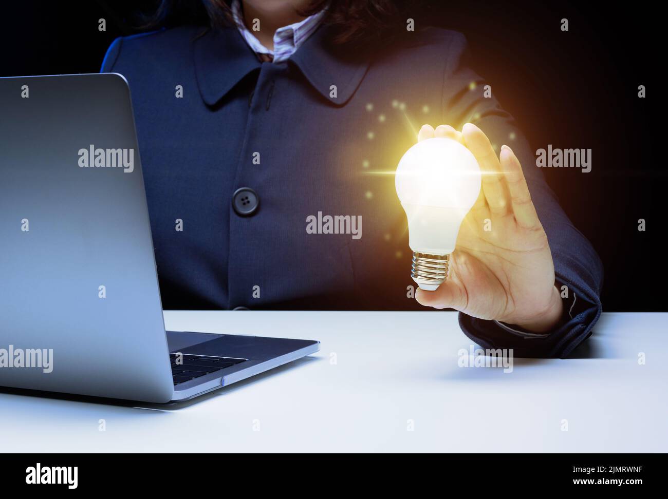 A woman's hand holds a light bulb, the concept of innovation through ideas and inspiration. Business development through the sea Stock Photo