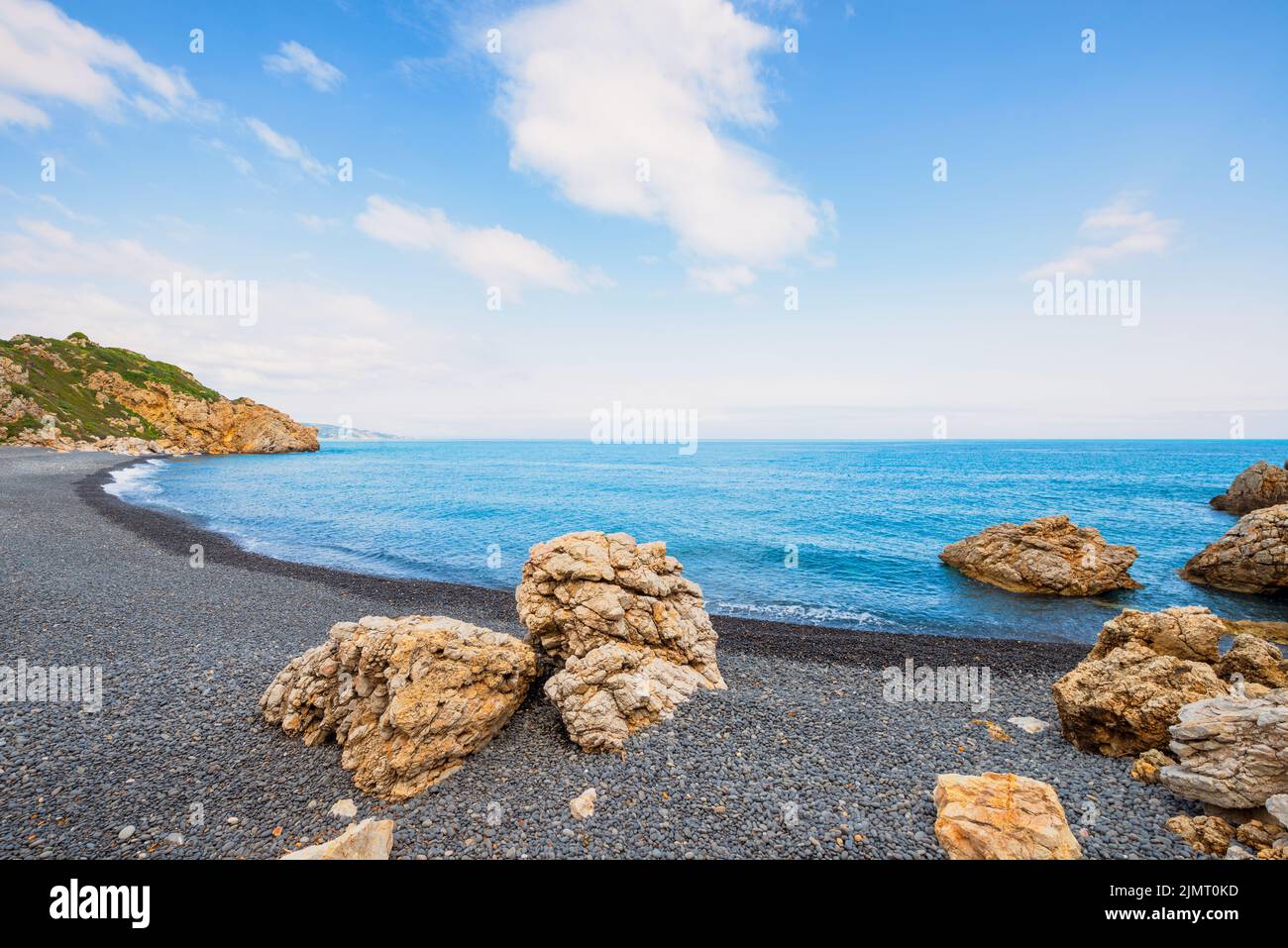 The Mavra Voila beach with black pebbles in Chios Greece with big rocks and a beautiful waterscape Stock Photo