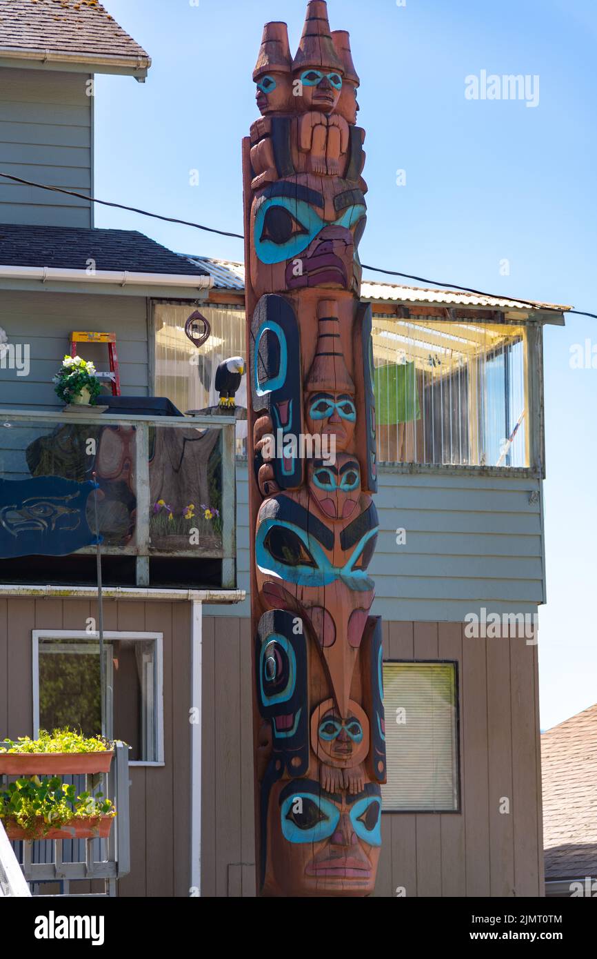 Privately commissioned Native Alaskan totem pole called featuring three watchman, an eagle, a raven and a man with a  walking stick outside a residence on Stedman Street, in Ketchikan, Alaska. Stock Photo
