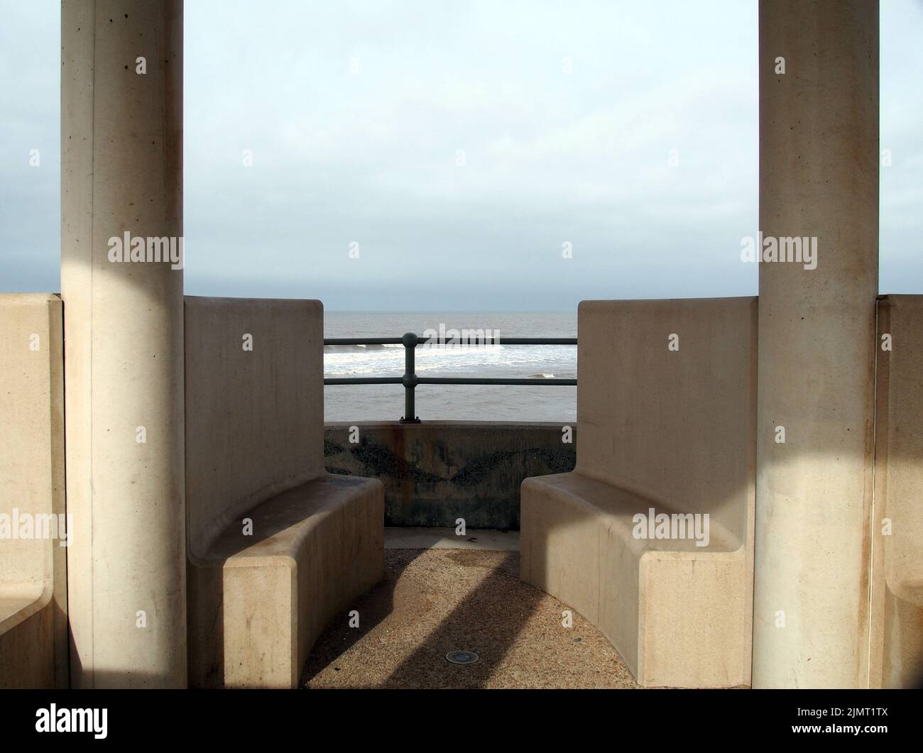 Concrete seats in a seafront shelter in cleveleys in merseyside Stock Photo