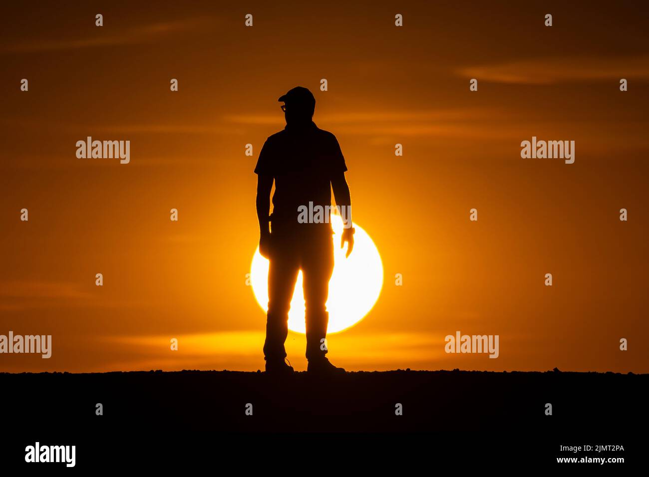 London, UK.  7 August 2022.  UK Weather – A man views the sunset at Northala Fields near Northolt in west London.  According to the Met Office, July 2022 was the driest July for England since 1935.  Hose pipe bans are in place in certain areas as drought conditions continue, with temperatures exceeding 30C in the south expected next week. Credit: Stephen Chung / Alamy Live News Stock Photo