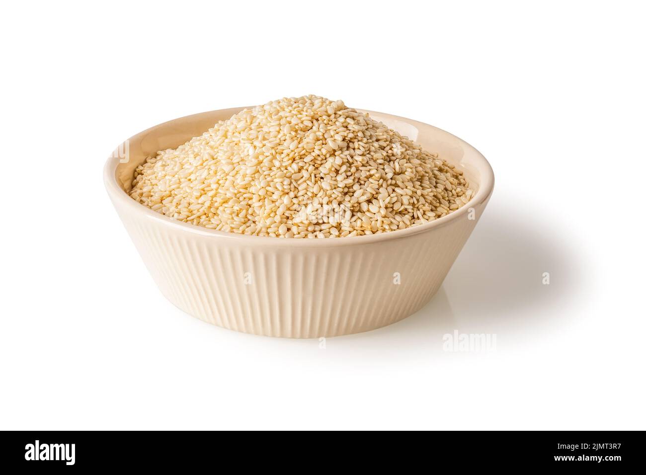 White sesame seeds in a beige bowl isolated on a white background. Heap of organic til grains on a plate cutout. Sesamum indicum for healthy eating. Stock Photo
