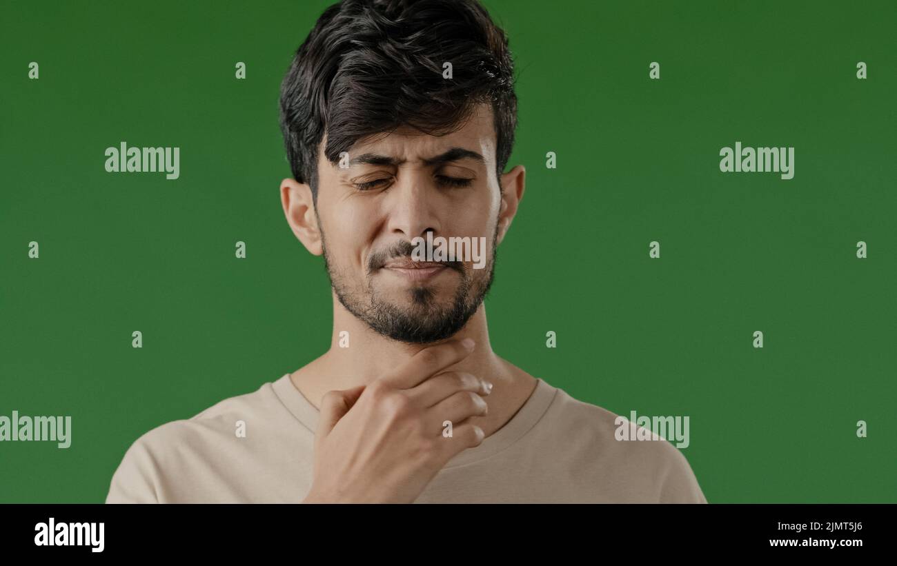 Indian sick young arab man touch neck suffer from angina has sore throat unhealthy guy painful swallow feel discomfort coronavirus disease symptom Stock Photo