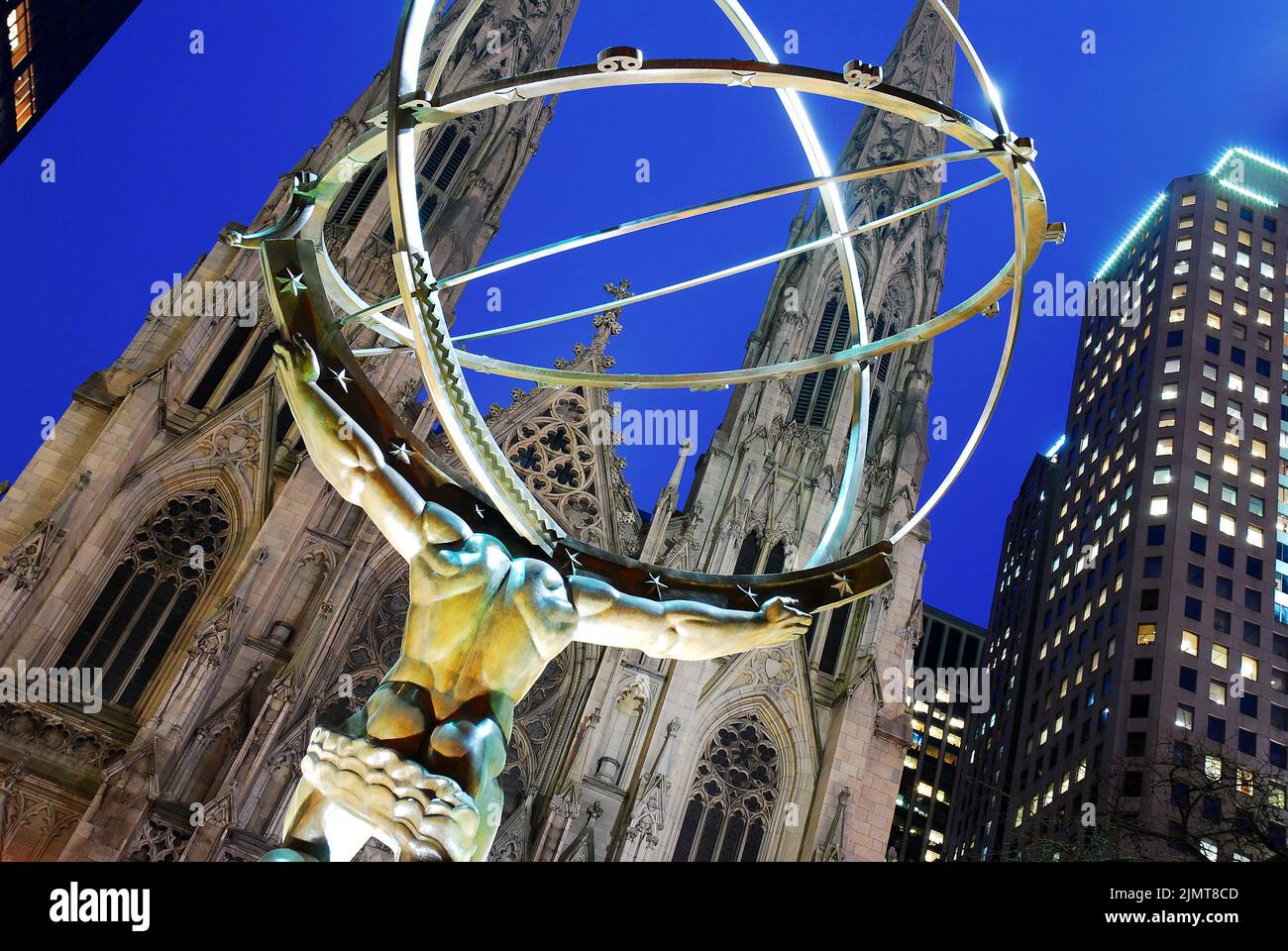 A sculpture of the Greek god Atlas holding the world stands in Rockefeller Center across the street from St Patrick's Cathedral in New York City Stock Photo