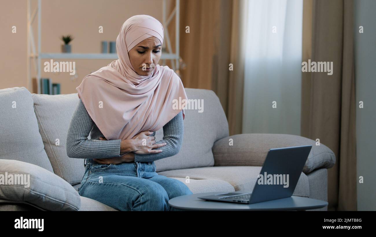 Young business woman muslim islamic arab girl in hijab sitting on sofa ...