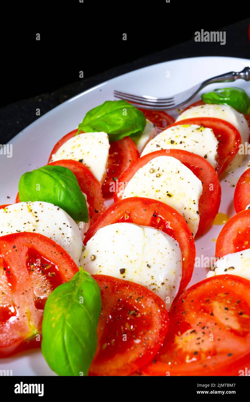 Tomato with mozzarella and basil Stock Photo - Alamy