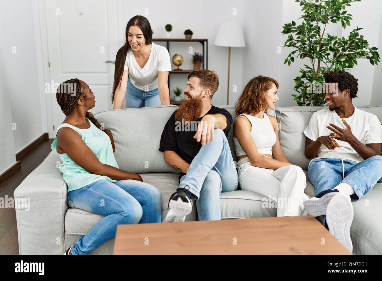 Group of young friends smiling happy sitting on the sofa at home Stock ...